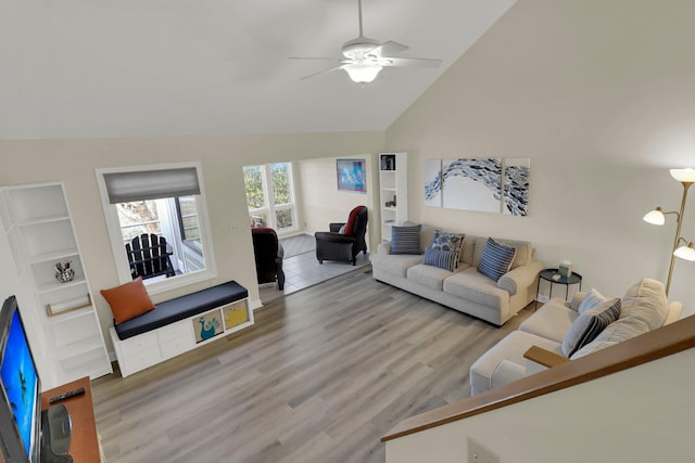 living room with lofted ceiling, wood-type flooring, built in features, and ceiling fan