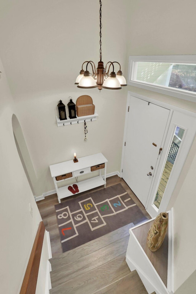 entryway with hardwood / wood-style flooring and a notable chandelier