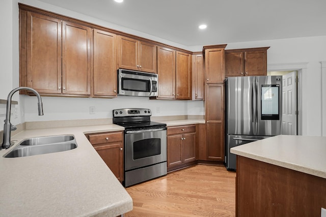 kitchen featuring sink, light wood-type flooring, and appliances with stainless steel finishes