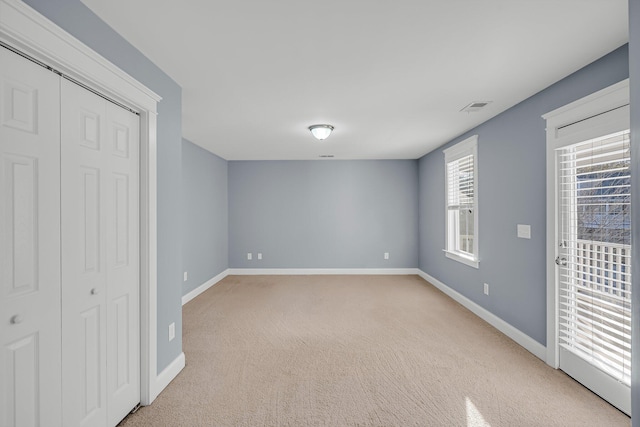 unfurnished bedroom with a closet, access to exterior, and light carpet