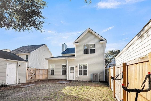 back of house with cooling unit and a yard