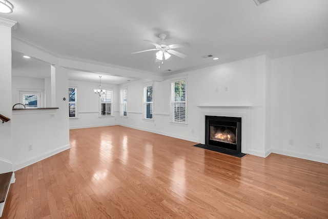 unfurnished living room featuring ceiling fan with notable chandelier, light hardwood / wood-style flooring, and ornamental molding