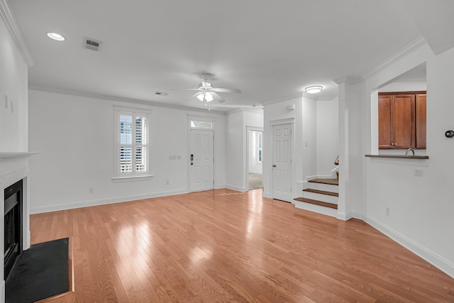 unfurnished living room featuring ceiling fan, light hardwood / wood-style flooring, and ornamental molding