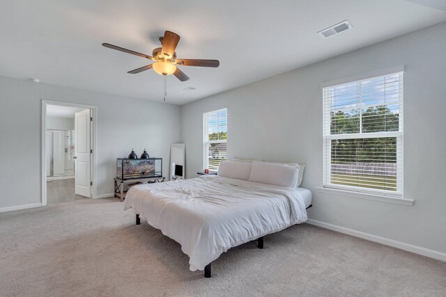 bedroom with connected bathroom, ceiling fan, and light colored carpet