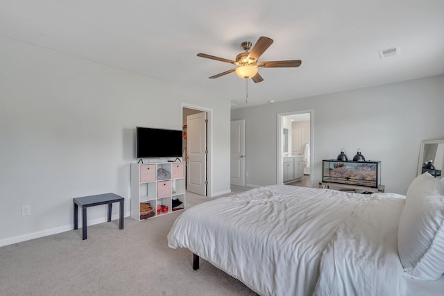 bedroom with ceiling fan, light carpet, and ensuite bath