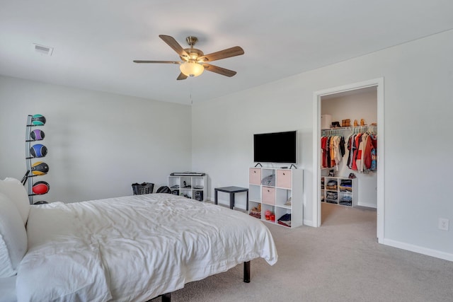 carpeted bedroom featuring ceiling fan, a walk in closet, and a closet