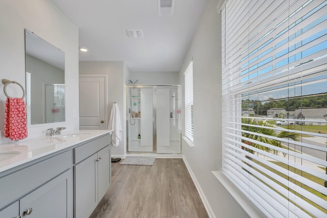 bathroom with hardwood / wood-style flooring, vanity, and a shower with shower door