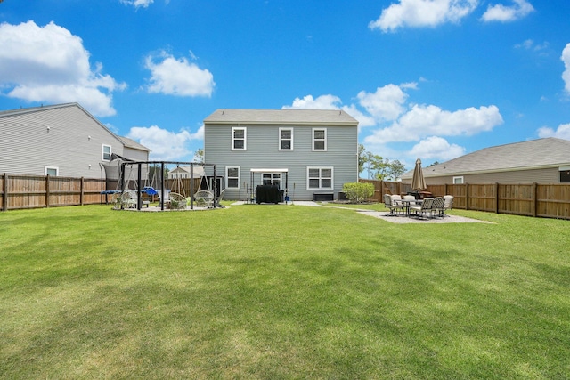 rear view of property featuring a yard and a patio area