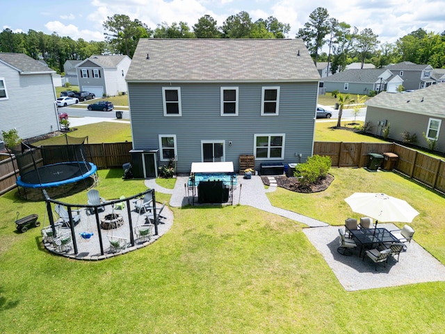 rear view of house featuring a lawn, a patio area, and a trampoline