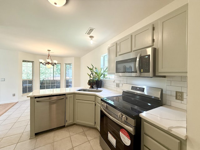 kitchen featuring stainless steel appliances, tasteful backsplash, a wealth of natural light, and a peninsula