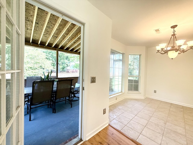 entryway featuring an inviting chandelier, baseboards, and visible vents