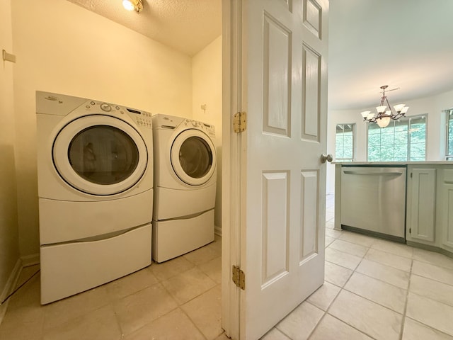 washroom featuring laundry area, independent washer and dryer, light tile patterned floors, and an inviting chandelier