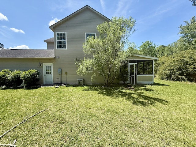 rear view of house with a yard and a sunroom