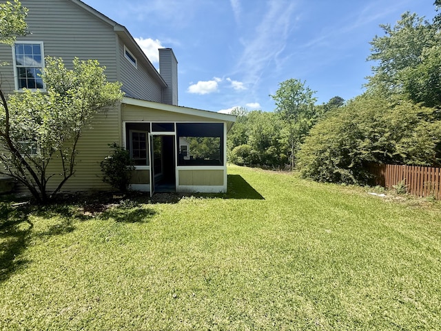 view of yard with a sunroom and fence