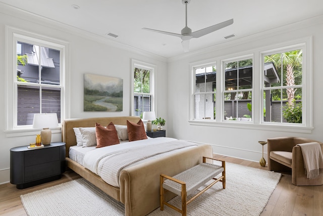 bedroom with crown molding, ceiling fan, and light hardwood / wood-style floors