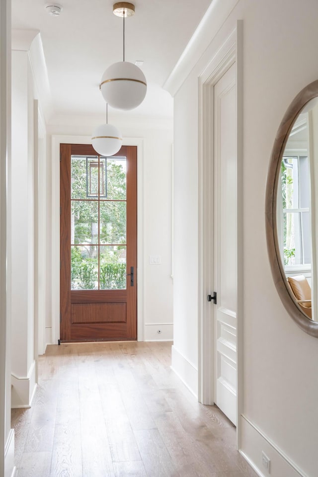 doorway featuring light hardwood / wood-style flooring and ornamental molding