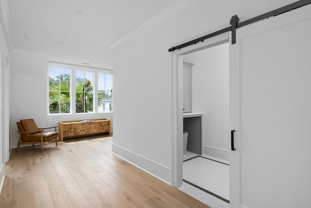 hall featuring a barn door and light wood-type flooring