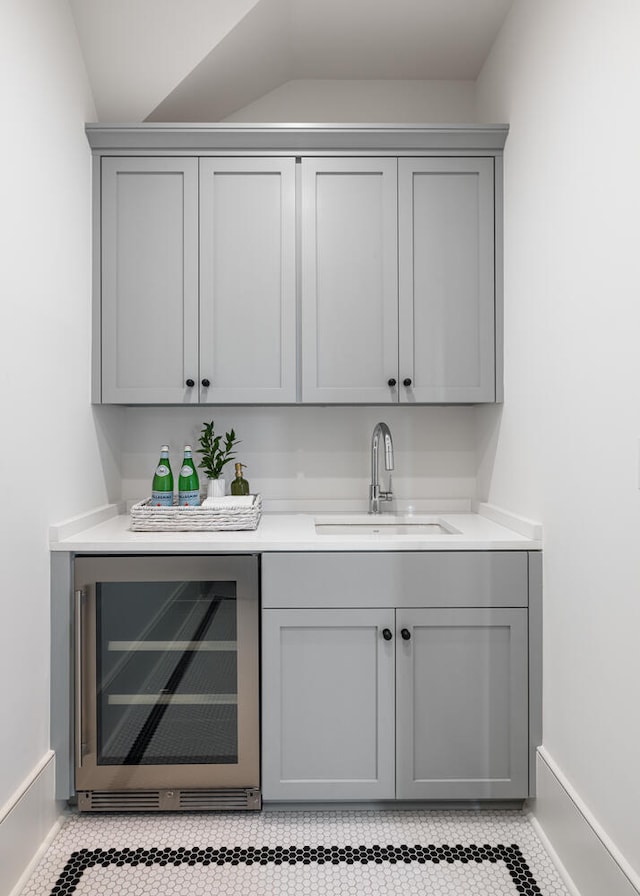 bar featuring wine cooler, sink, and gray cabinets