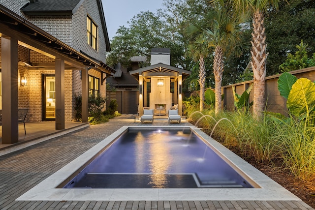 view of swimming pool with pool water feature, an outdoor living space, and a patio area