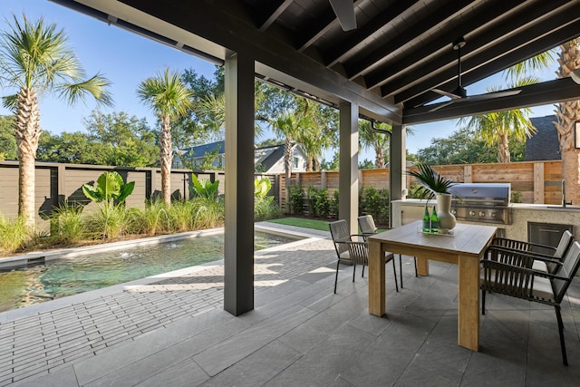 view of patio / terrace with a fenced in pool, area for grilling, and sink