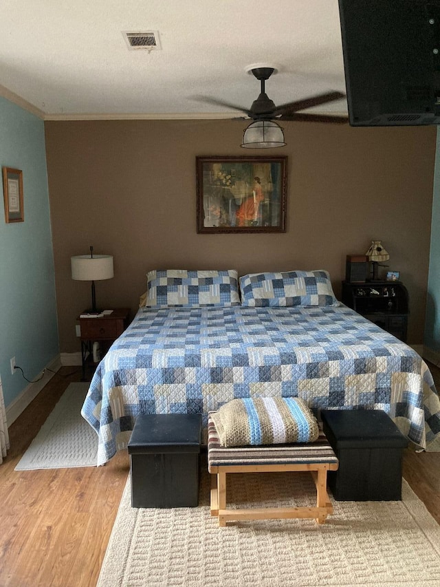 bedroom featuring hardwood / wood-style floors and crown molding