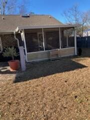 rear view of property featuring a sunroom