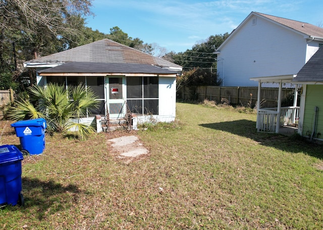 view of yard with a sunroom and fence