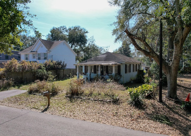 view of front of home with covered porch and fence