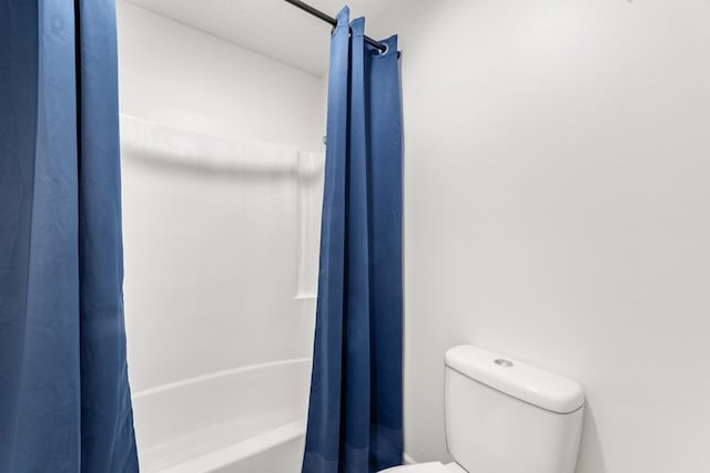 bathroom featuring shower / bath combo with shower curtain and toilet