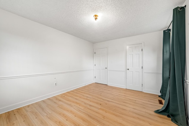 unfurnished bedroom featuring a textured ceiling and light hardwood / wood-style flooring