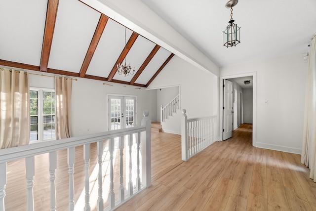 hallway with light hardwood / wood-style flooring, french doors, beam ceiling, and a chandelier