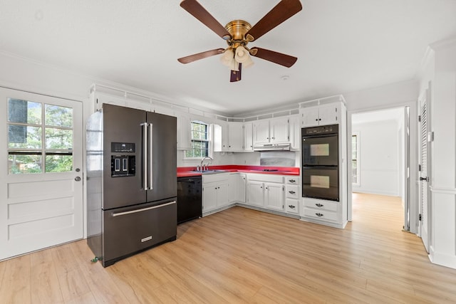 kitchen with white cabinets, light hardwood / wood-style floors, a healthy amount of sunlight, and black appliances