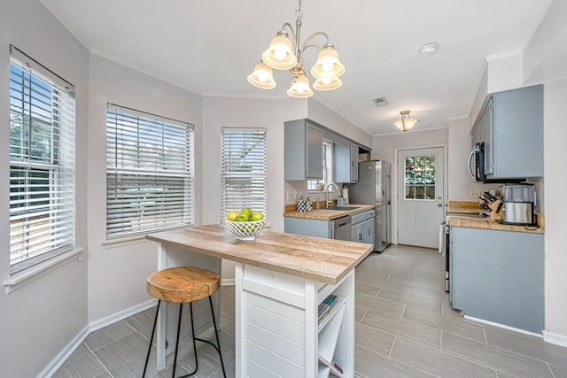 kitchen with crown molding, appliances with stainless steel finishes, and gray cabinetry