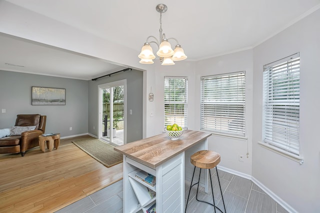 dining room with crown molding, a notable chandelier, and light hardwood / wood-style flooring