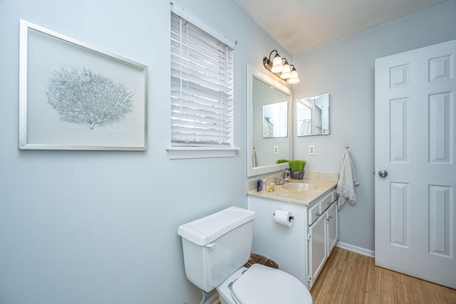 bathroom featuring vanity, hardwood / wood-style flooring, and toilet