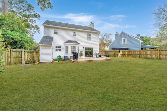 rear view of property with a wooden deck and a lawn