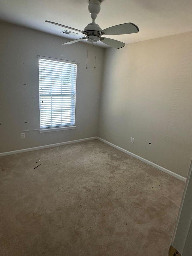 empty room with light carpet, ceiling fan, visible vents, and baseboards