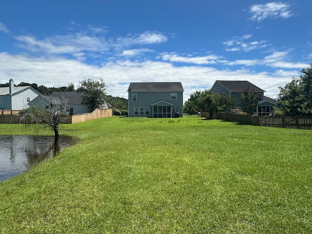 view of yard with a water view and fence