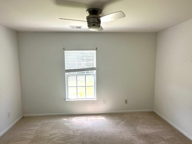 unfurnished room featuring light colored carpet, ceiling fan, visible vents, and baseboards