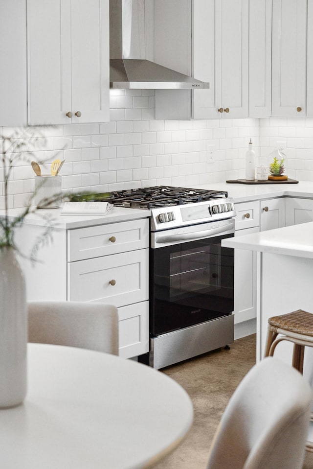 42 Poinsett St Unit B, Charleston, SC 29403 - kitchen featuring range hood, stainless steel range with gas stovetop, light countertops, white cabinetry, and backsplash