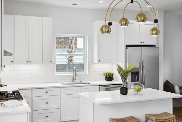42 Poinsett St Unit B, Charleston, SC 29403 - kitchen featuring stainless steel appliances, a sink, backsplash, white cabinets, and light countertops