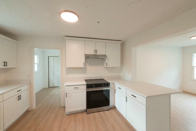 kitchen with kitchen peninsula, white cabinets, stainless steel electric range oven, and light hardwood / wood-style flooring