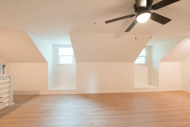 additional living space with ceiling fan, light hardwood / wood-style flooring, and vaulted ceiling