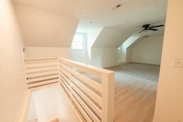 additional living space with light hardwood / wood-style floors, vaulted ceiling, and ceiling fan