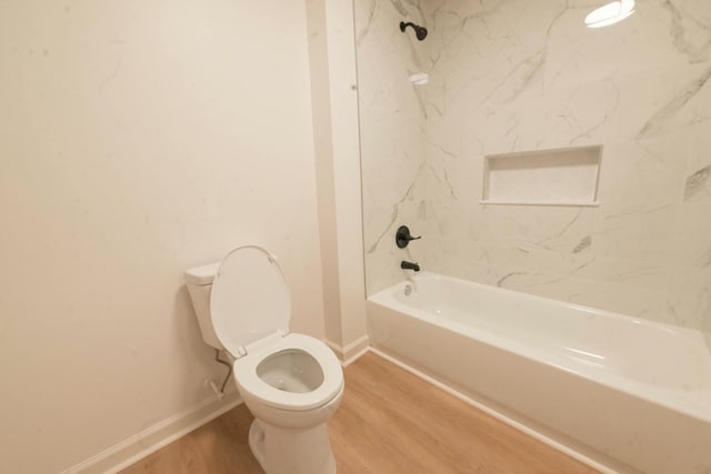 bathroom featuring tiled shower / bath combo, hardwood / wood-style flooring, and toilet