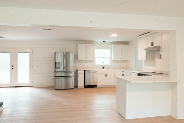 kitchen featuring pendant lighting, white cabinetry, sink, and stainless steel appliances