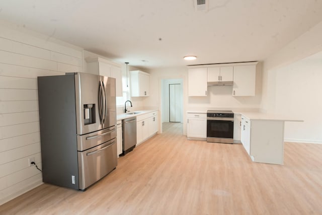 kitchen with light hardwood / wood-style flooring, white cabinets, and appliances with stainless steel finishes