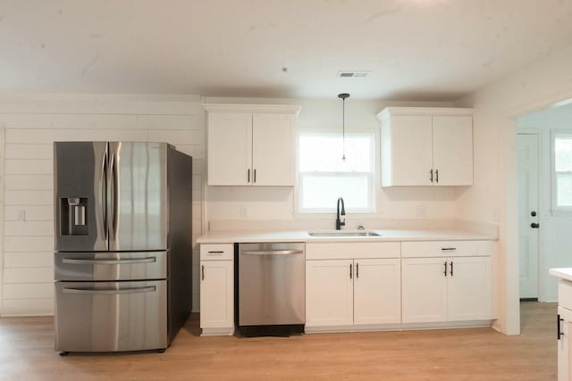 kitchen with pendant lighting, sink, stainless steel appliances, and plenty of natural light