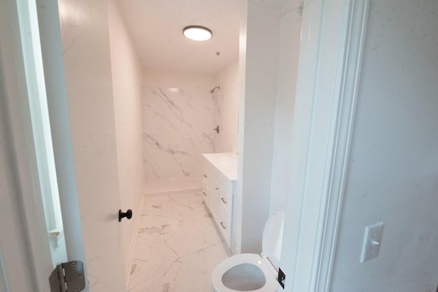 bathroom featuring tiled shower, vanity, and toilet