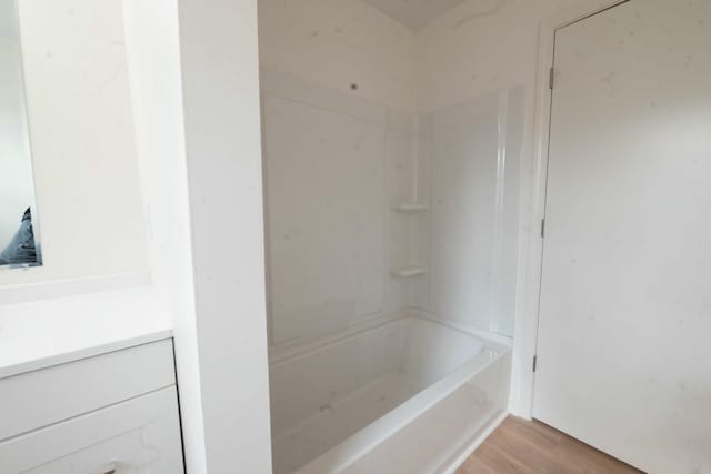 bathroom with bathing tub / shower combination and hardwood / wood-style floors